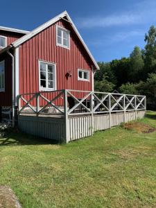 a red barn with a white fence in front of it at Haus Lasse in Immeln