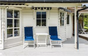 2 blaue Stühle und ein Tisch auf der Veranda in der Unterkunft Gorgeous Home In Førde I Hordaland in Førde + 22 Fotos