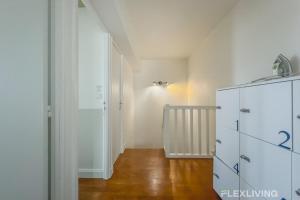 a room with a white refrigerator and a hallway at Flexliving - room - Losserand in Paris