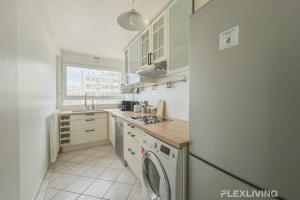 eine Küche mit einem Kühlschrank und einer Waschmaschine in der Unterkunft Flexliving - room - Losserand in Paris