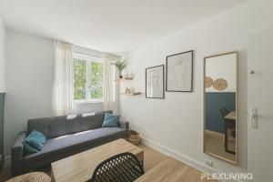 a living room with a couch and a mirror at Flexliving - Room - Friant in Paris