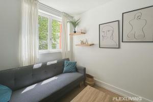 a living room with a couch and a window at Flexliving - Room - Friant in Paris