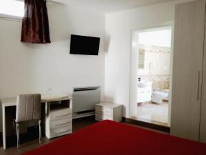 una stanza bianca con una scrivania e una TV sul muro di Arcona a Serrano