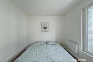 une chambre avec un lit dans une pièce blanche dans l'établissement Flexliving - Room - Henri Sellier - Suresnes 92, à Suresnes