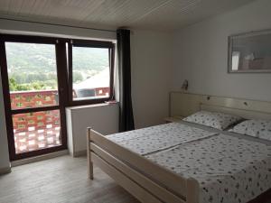 a bedroom with a bed and a large window at KATY&MLADEN in Baška