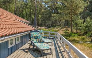 une terrasse couverte avec 2 chaises et une maison dans l'établissement Holiday Home Mejsevej Nexø Ii, à Spidsegård