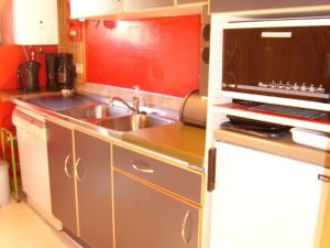 a kitchen with a sink and a microwave at Ein Chalet mit großem Garten und Panoramablick in Rochefort