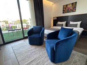 a hotel room with a bed and two blue chairs at Executive Boutique Hotel Rabat in Rabat