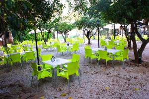 a group of tables and chairs with yellow chairs at Hotel Los Bartolos in Alhama de Murcia