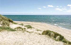 ein Sandstrand mit dem Meer im Hintergrund in der Unterkunft Fyrreroden in Vester Sømarken