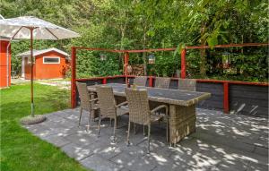 a table with chairs and an umbrella on a patio at Skovlæ in Neksø