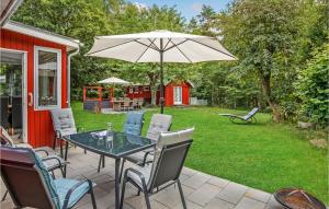 a patio with a table and chairs and an umbrella at Skovlæ in Neksø