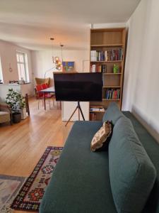 a living room with a couch and a piano at Pæn central lejlighed med gratis parkering in Randers