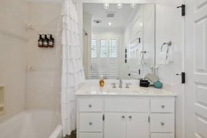 a white bathroom with a sink and a bath tub at Charming Cottage and Guest House a block to beach! in Gulfport +84 photos