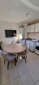 una cocina con mesa de madera y sillas. en Los Cohiues Temporario, en Río Grande 6 fotos más