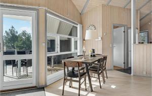 a dining room with a table and some windows at Klitbo in Rømø
