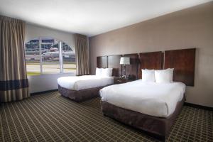 a hotel room with two beds and a window at Clarion Inn & Suites Miami International Airport in Miami