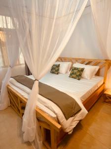 a bedroom with a bed with a mosquito net at Tukutane Kilimanjaro - Homestay in Uru