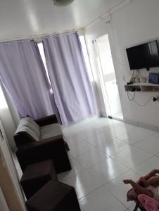 a living room with a couch and a tv at Casa in Campina Grande