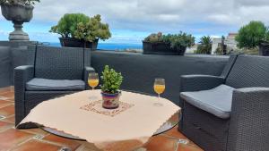 een tafel met twee glazen wijn op een patio bij Apartamentos Monasterio de San Antonio - adults only in Icod de los Vinos