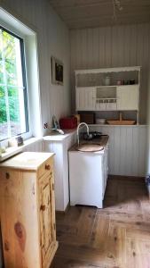 a kitchen with white cabinets and a sink and a window at Svečių namelis KNYGŲ NAMAS in Kelmė