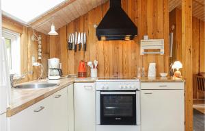 eine Küche mit Herd und Spüle in der Unterkunft 3 Bedroom Cozy Home In Nexø in Neksø + 13 Fotos