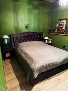 a bedroom with a large bed with green walls at Svečių namelis KNYGŲ NAMAS in Kelmė +22 photos