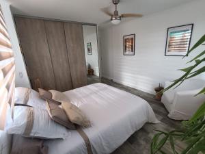 Maison Magnolia في Marcorignan: غرفة نوم بسرير ابيض عليها مخدات