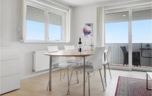 a dining room with a table and white chairs at Casa Blanca in Gudhjem