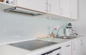 a kitchen with a sink and white cabinets at Casa Blanca in Gudhjem