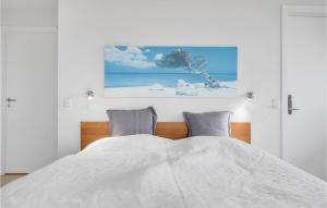 a white bedroom with a bed with two pillows at Casa Blanca in Gudhjem +12 photos