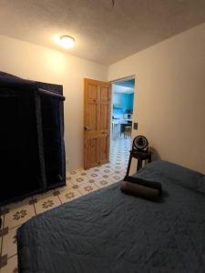 Un dormitorio con una cama y una puerta a una cocina. en Downtown, en Quepos