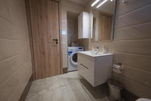 a bathroom with a sink and a washing machine at Armonia House in Dhíkella