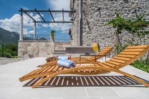 a pair of wooden lounge chairs and a table at Villa Le Adria - Privat HotTub - Kostenloser Strandparkplatz in Kozica