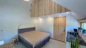 a bedroom with a bed and a wooden door at JouwvakantiehuisNL 8 persoons cottage in Vries +28 photos