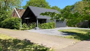 a house with a gambrel roof and a driveway at JouwvakantiehuisNL 8 persoons cottage in Vries