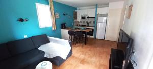een woonkamer met een bank en een keuken bij Entre Golf et Mer in Pornic +15 foto's