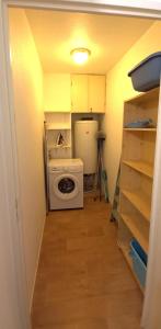 een wasruimte met een wasmachine en een koelkast bij Entre Golf et Mer in Pornic