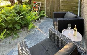 a patio with a table with a bottle of wine at Cozy Home In Noordscheschut With Wifi in Noordscheschut +12 photos