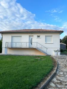 a house with a balcony in front of a yard at Maison 3 chambres, piscine in Tonneins