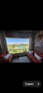 a view of a room with a couch and a window at Marrakech Golf City Prestigia 4 minutes du centre in Marrakech