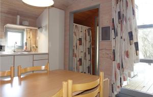 a kitchen and dining room with a wooden table and chairs at Stunning Home In Nexø With Wifi in Neksø