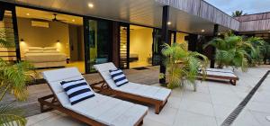 two lounge chairs on a patio in a house at Pacific Palms Luxury Villa in Rarotonga