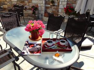 ein Tisch mit einem Teller Essen und Blumen darauf in der Unterkunft Hotel Ilianna in Portaria