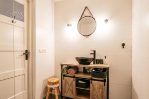 a bathroom with a sink and a mirror on the wall at Klooster Achthuizen in Achthuizen