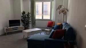 a living room with a blue couch and a tv at Appartement près de la gare St Charles in Marseille