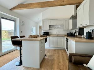 a kitchen with white cabinets and a large window at Apple Store- Countryside Apartment in Trowbridge