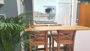 a kitchen with a wooden table and some chairs at Posada 3q blue sky in Posada de Llanes +19 photos