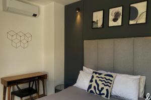 ein Schlafzimmer mit einem Bett mit zwei Bildern an der Wand in der Unterkunft Lapso At Alarcón in Guadalajara