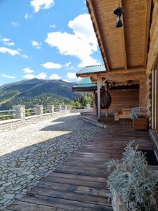a wooden walkway next to a building with mountains in the background at Cabanele Borsa View in Borşa